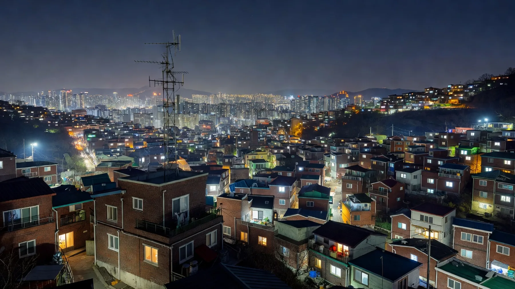 옥상에 세워진 라디오 안테나와 도시 불빛